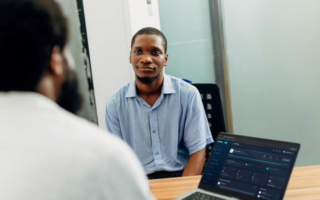 Student meeting his mentor, with the Wimentor mentor dashboard open on a laptop
